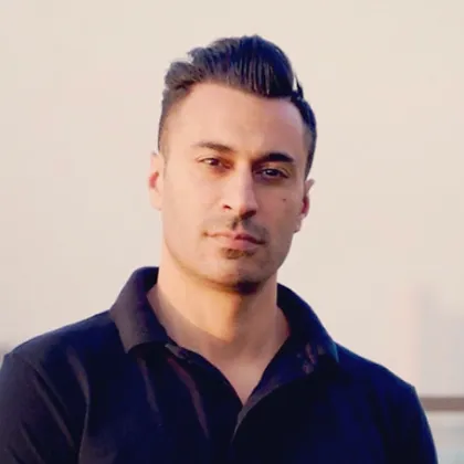 A person wearing a black polo shirt stands outside, looking directly at the camera with a neutral expression, capturing a moment amid an enriching Experience Tunisia tour. A person wearing a black polo shirt stands outside, looking directly at the camera with a neutral expression, capturing a moment amid an enriching Experience Tunisia tour.