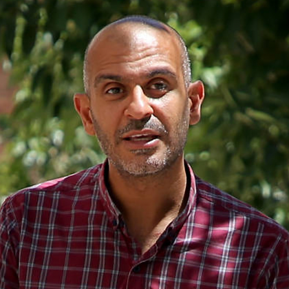 A person wearing a red plaid shirt stands outdoors with trees in the background, perhaps dreaming of tailor-made Tunisia private tours to discover the country’s rich tapestry of landscapes and culture. A person wearing a red plaid shirt stands outdoors with trees in the background, perhaps dreaming of tailor-made Tunisia private tours to discover the country's rich tapestry of landscapes and culture.