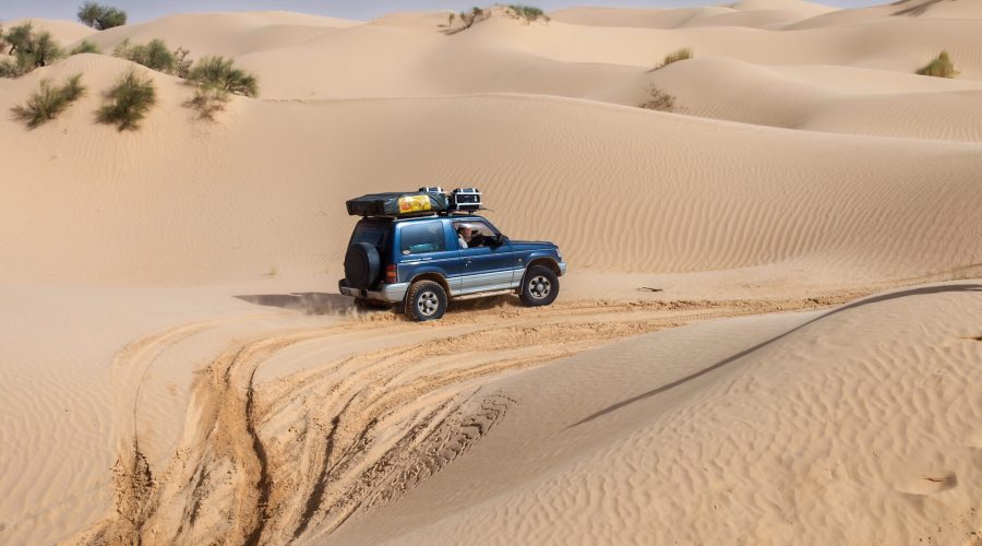 Embark on an unforgettable tour as your SUV navigates the sandy desert dunes of Tunisia, leaving tire tracks behind and carrying luggage on the roof. Experience Tunisia's breathtaking landscapes and adventure at every turn.