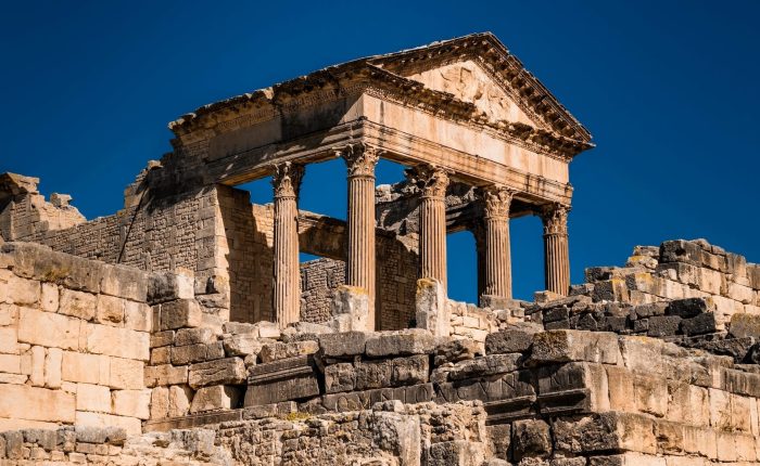 Discover the ancient Roman temple ruins with their majestic columns and stone structures under a clear blue sky. Experience Tunisia through tailored tours that reveal the historical wonders and hidden gems of this captivating land.